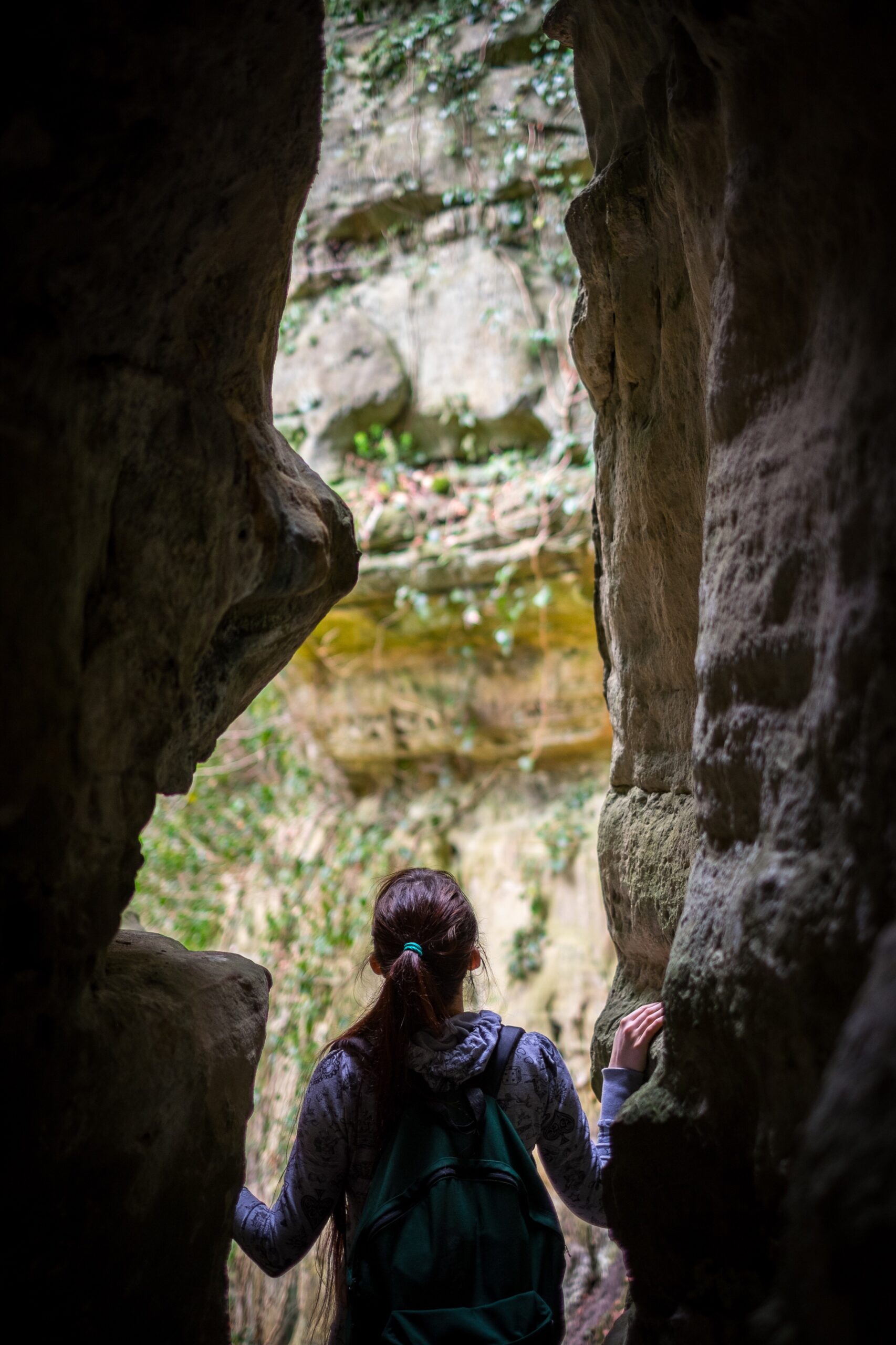 rear-view-woman-standing-amidst-rock-formations